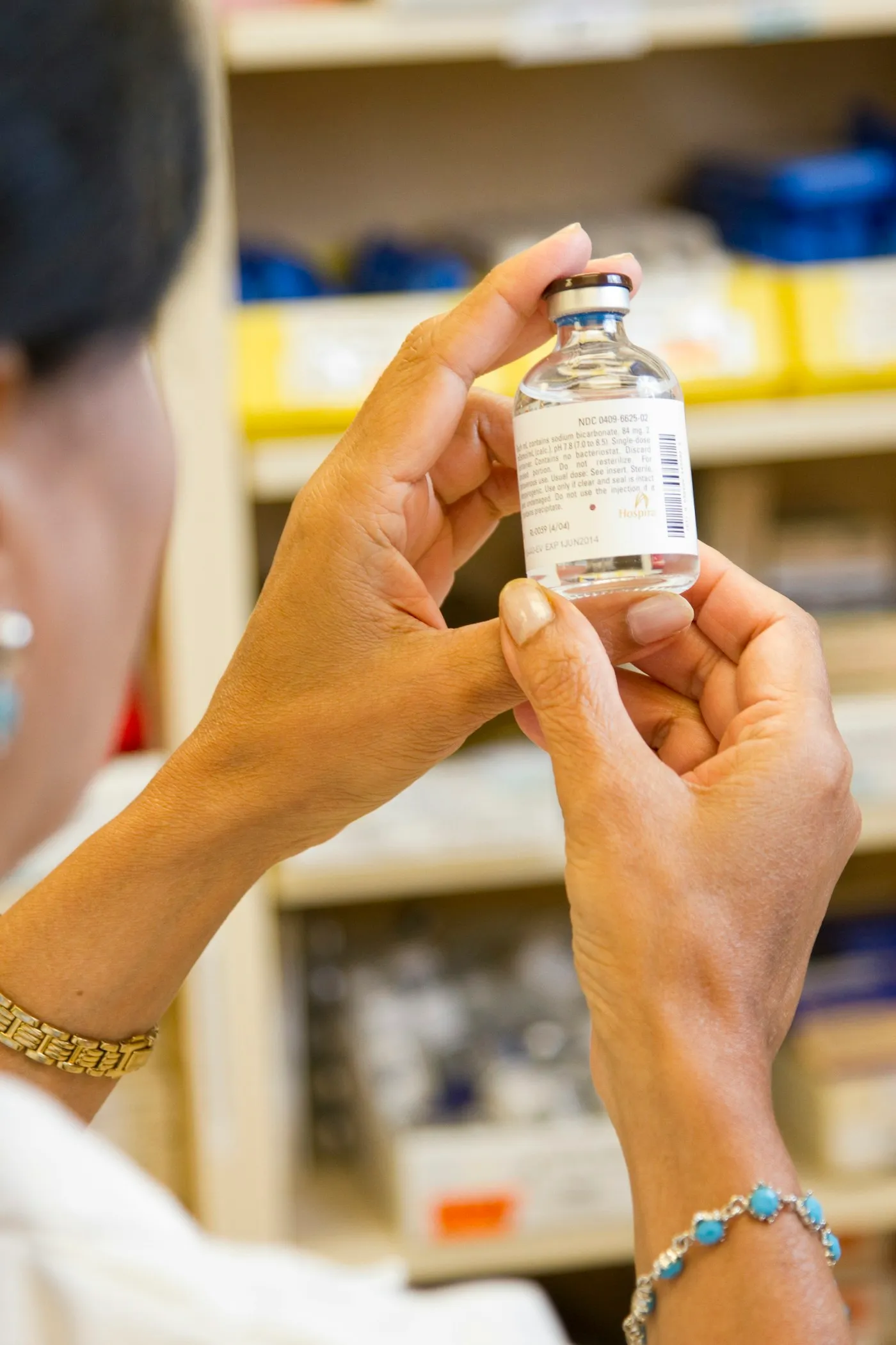 A pharmacist examining a labelled medicine vial