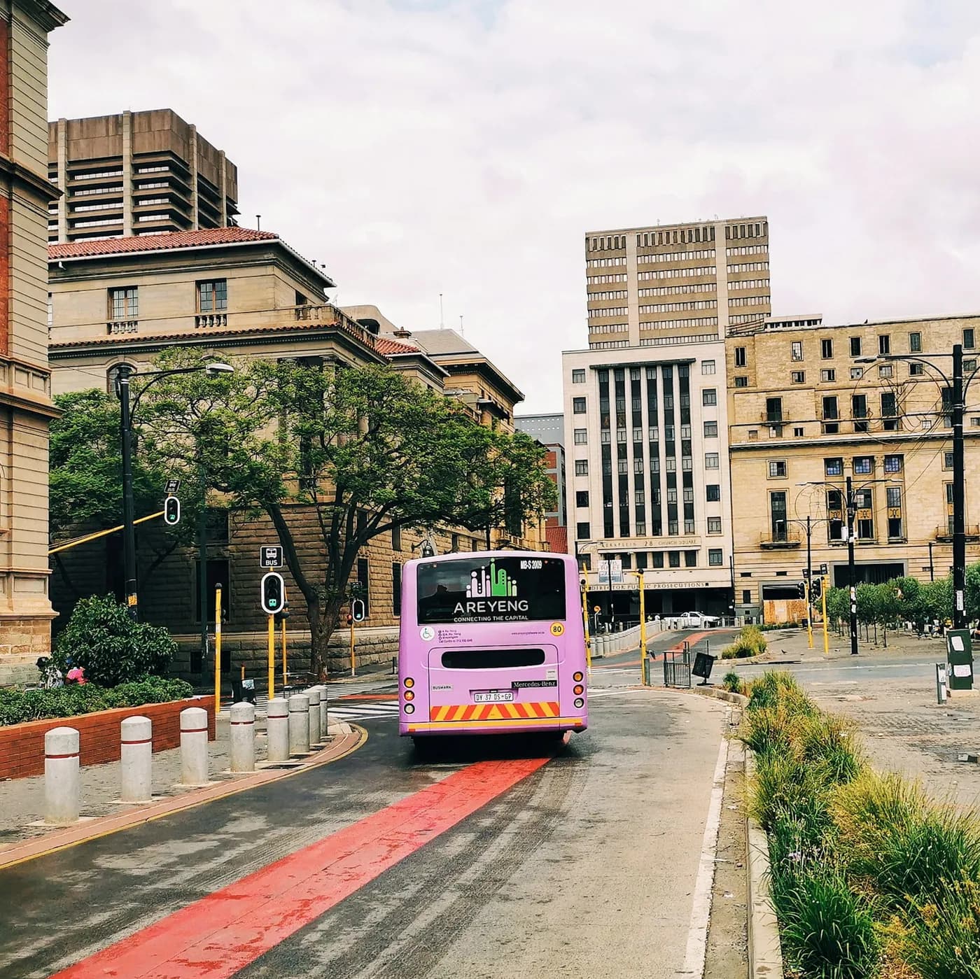 A bus travelling past city buildings near Church Square in Pretoria