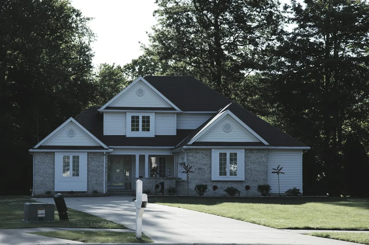A modern suburban house with a green lawn and trees