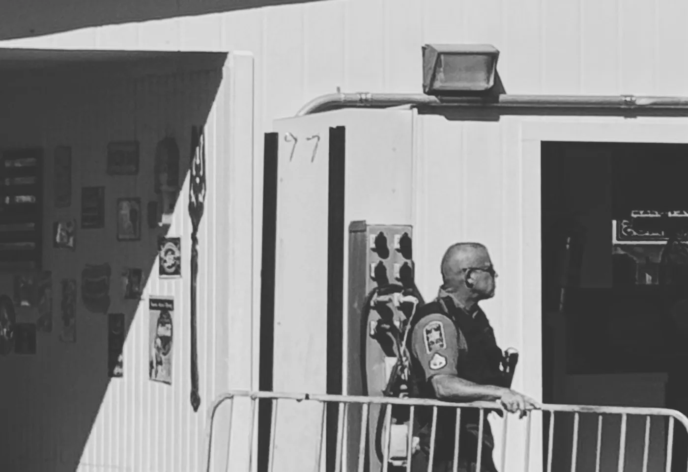 A uniformed security guard standing beside a building entrance